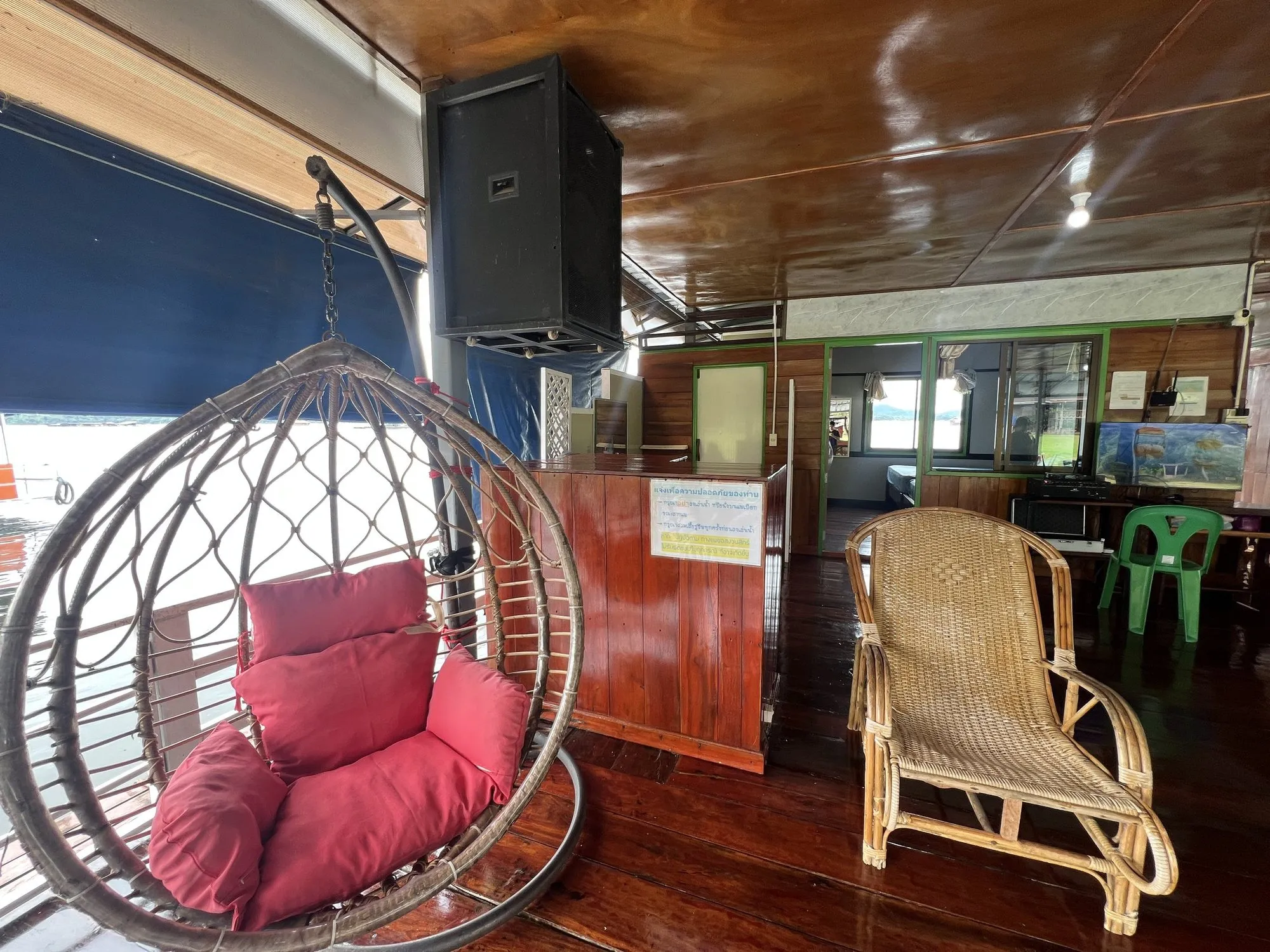A hanging egg chair on the varnished deck of a raft house on Khao Laem Lake, Thailand.